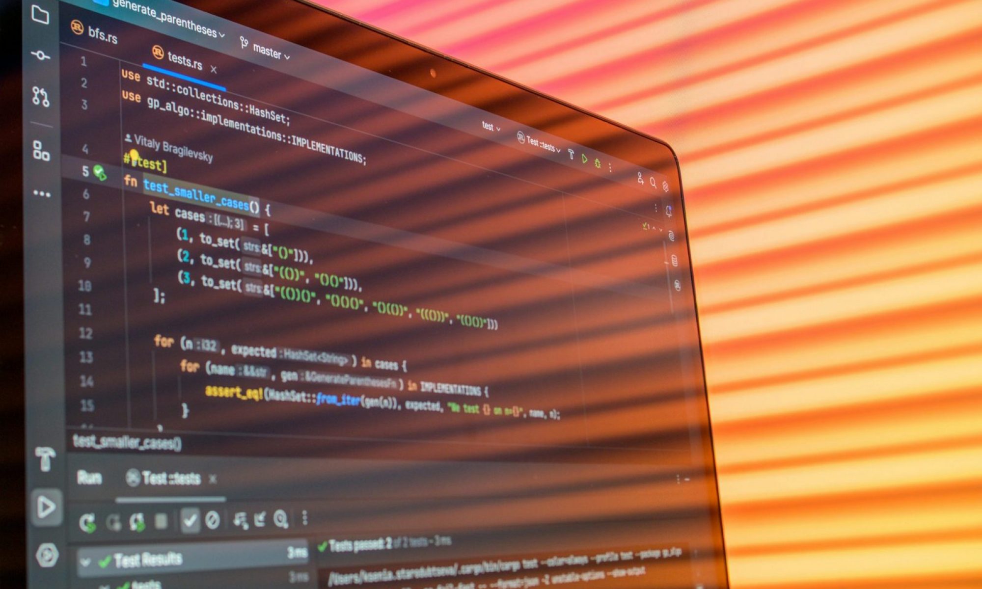Colorful abstract reflection on screen showing programming code in development environment.